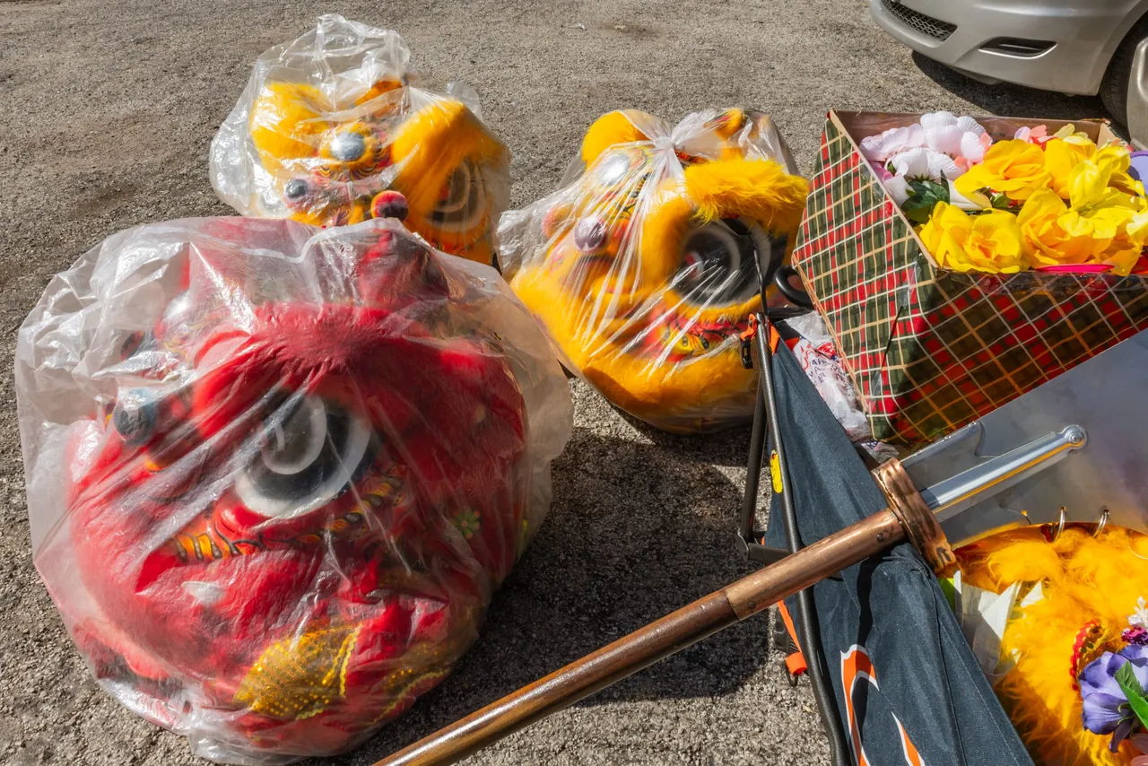 Lion dance heads wrapped in plastic on the ground