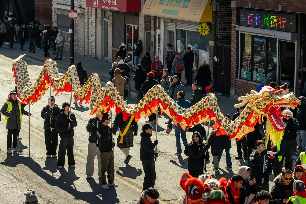 A dragon dance winds down a city street