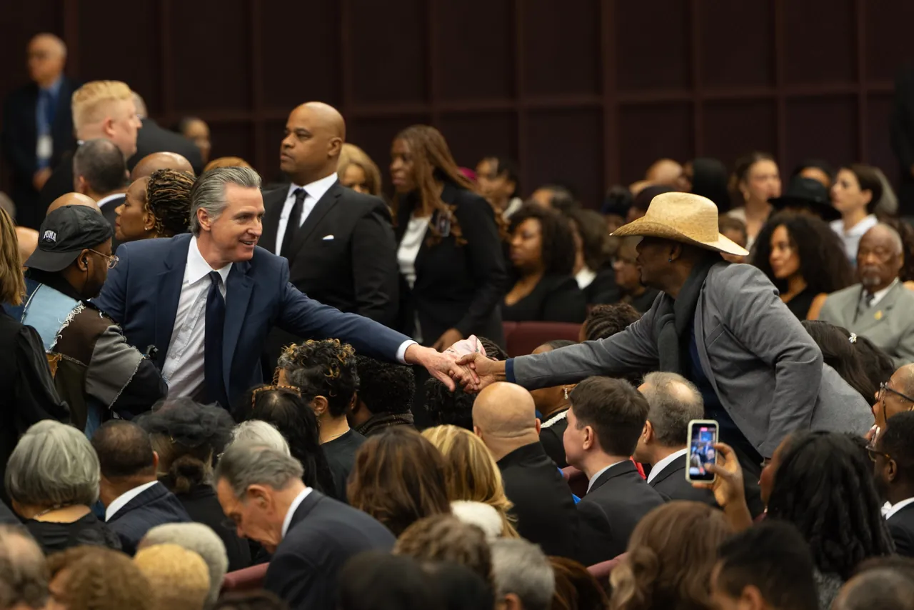 Mourners reach across rows of seats to shake hands
