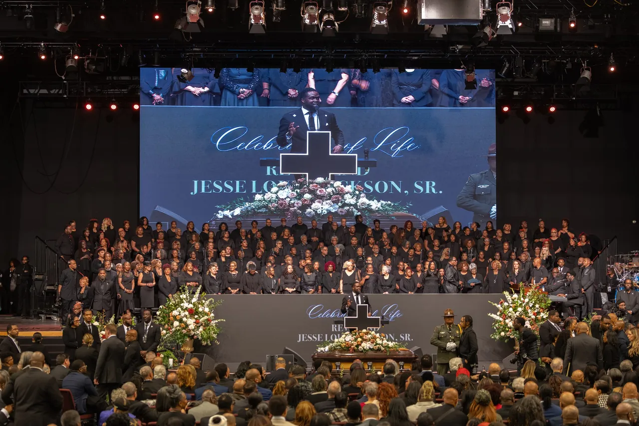 The full arena during the service, a screen above the stage reading Celebration of Life
