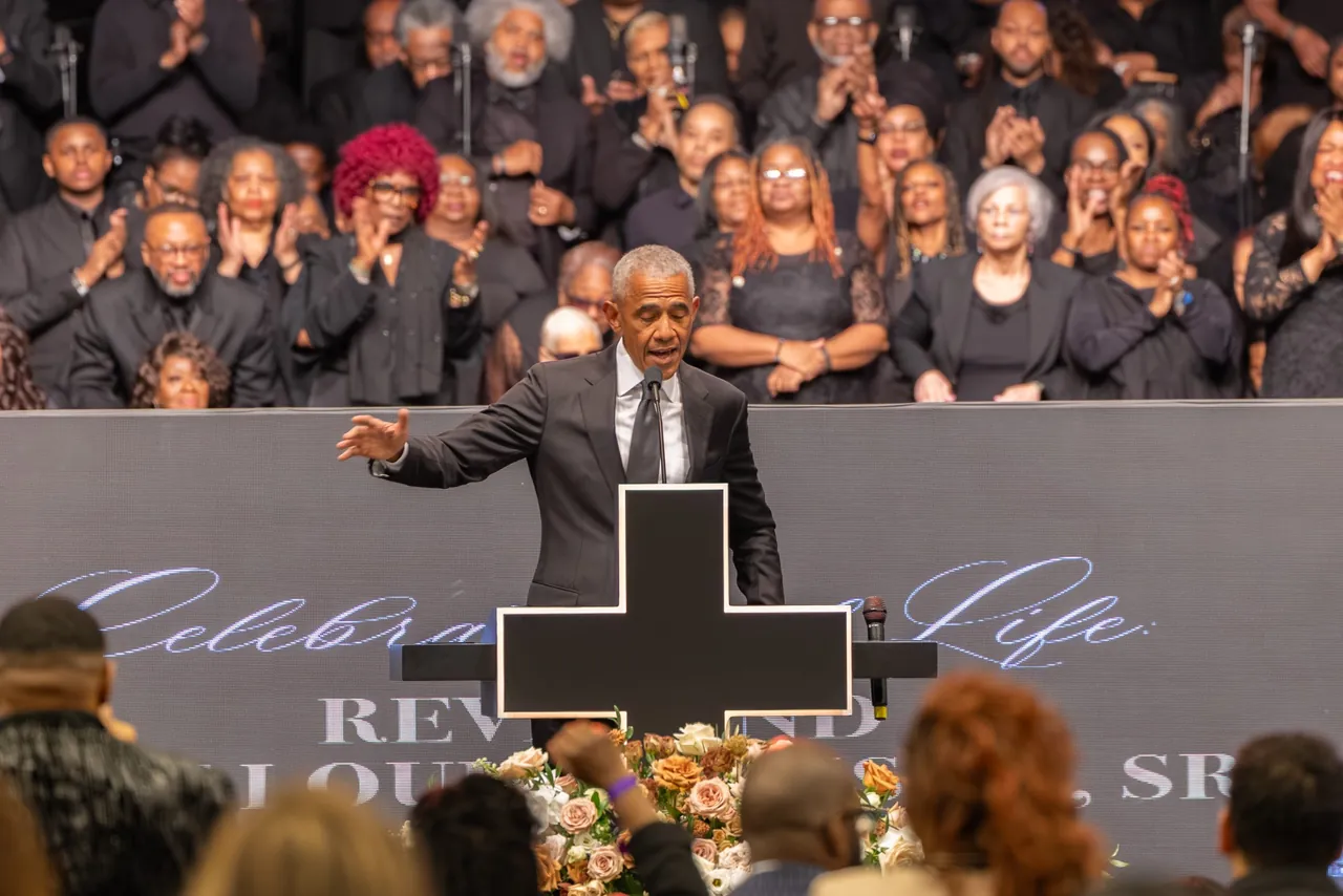 A speaker gestures from the lectern toward the crowd
