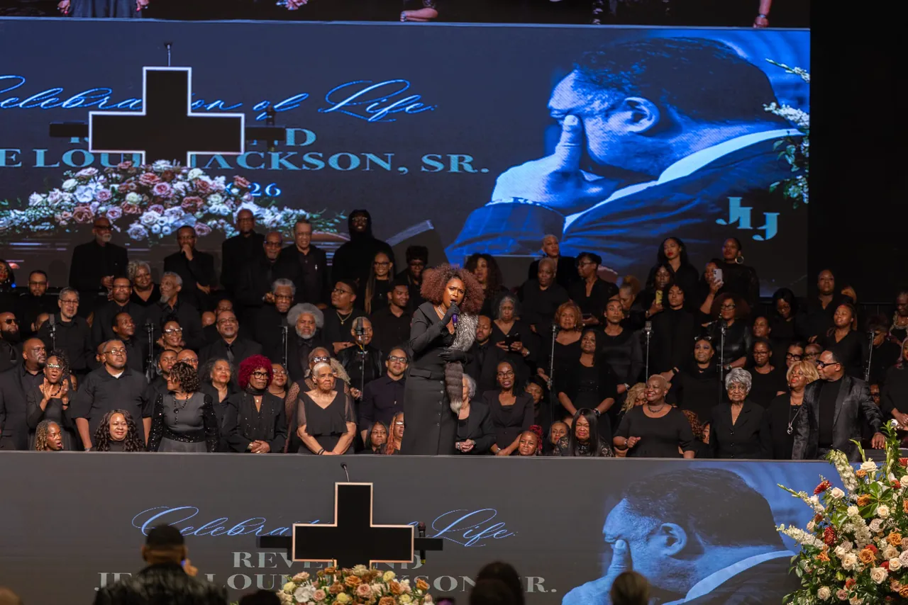 The stage seen from the floor, with Rev. Jackson on the screen above the choir