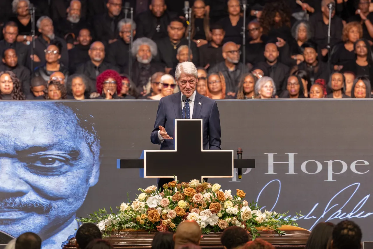 A speaker at the lectern, the portrait of Rev. Jackson behind him