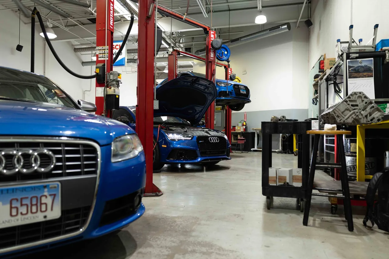 A blue Audi parked in the shop, lifts behind it