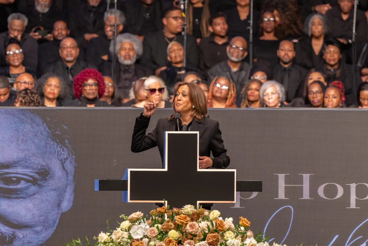 A speaker raises a hand at the lectern