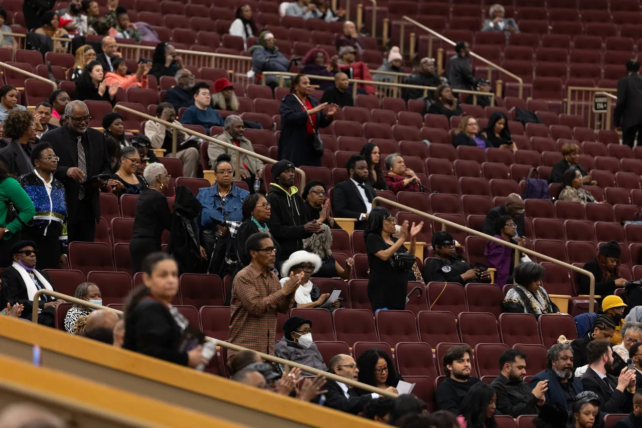 Mourners seated in the upper rows of the arena