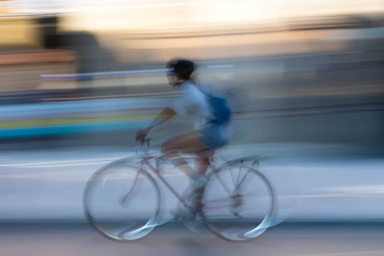 A cyclist blurred against the street