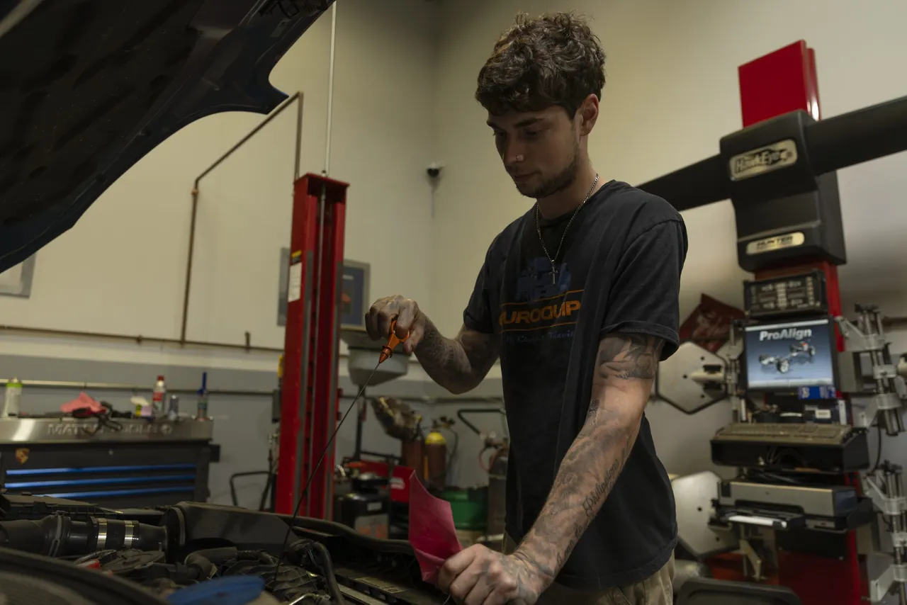 A mechanic at a workbench under a lift