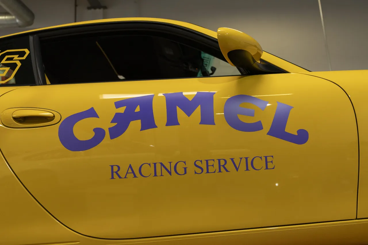 A yellow car door lettered Camel Racing Service