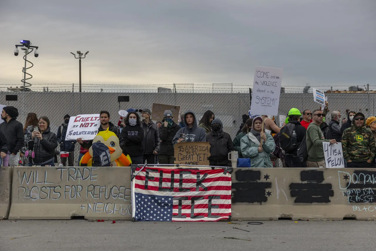 Demonstrators behind concrete barriers, an upside-down American flag hung in front