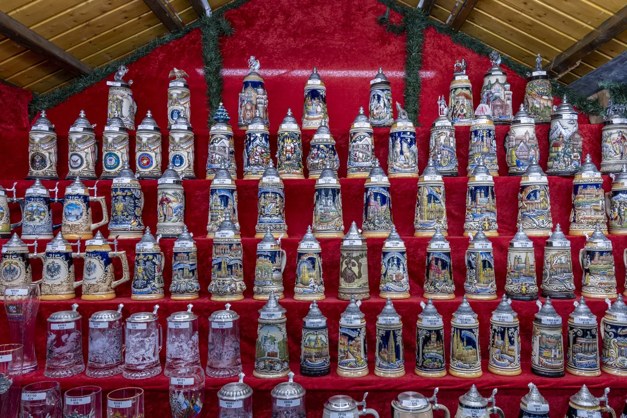 A wall of beer steins on red shelves