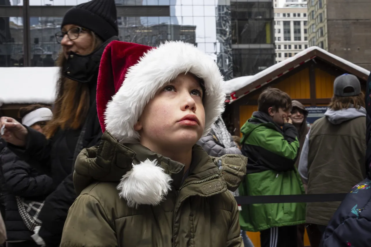 A child in a Santa hat looks up at the market