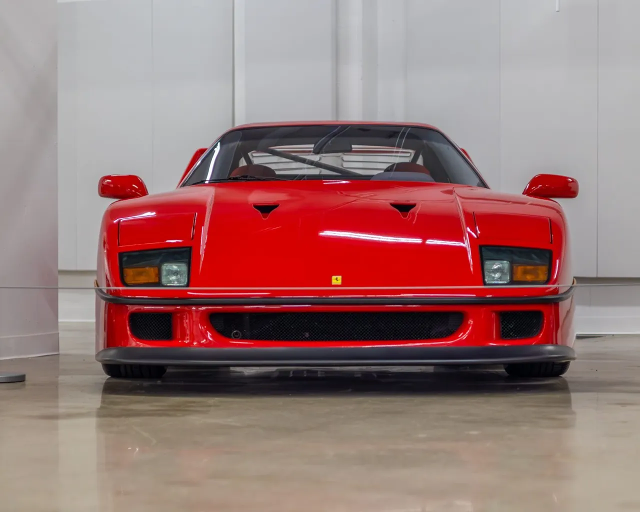 A red Ferrari F40 head-on in a white room