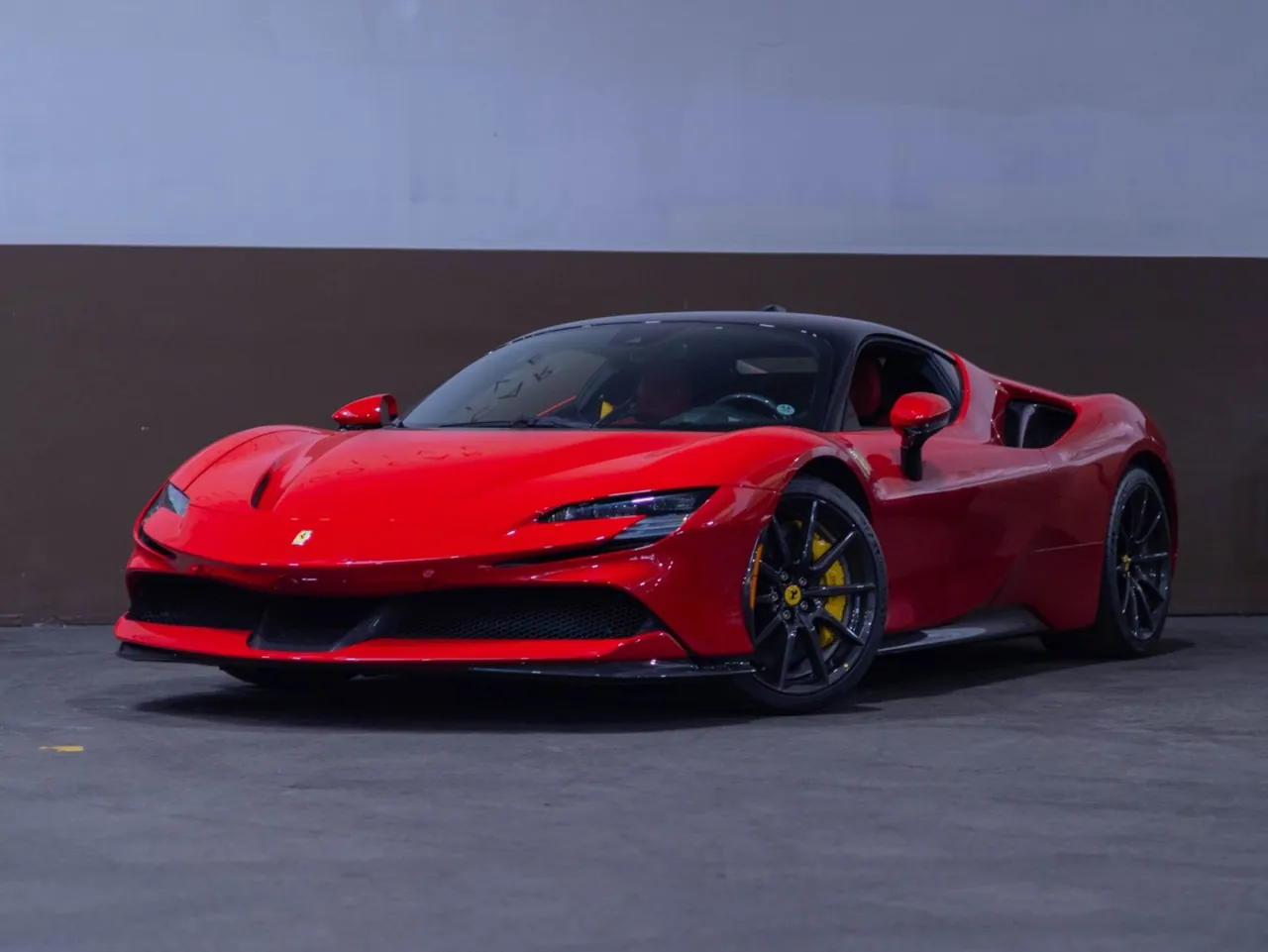 A red Ferrari against a gray wall