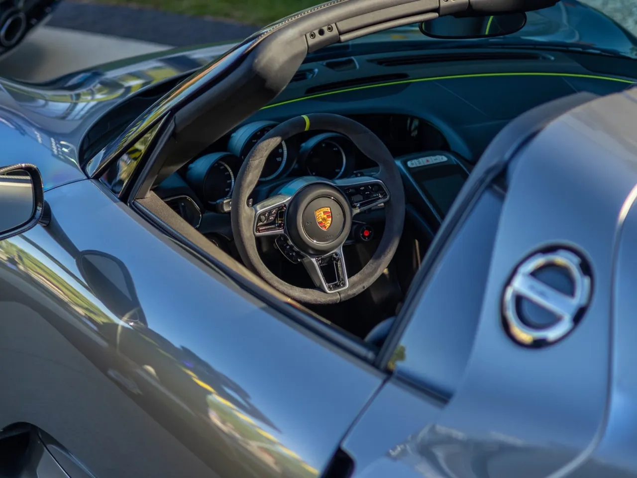Looking down into the open cockpit of a silver Porsche