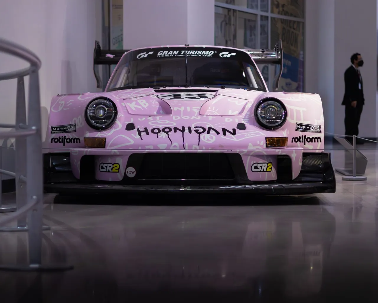 A pink Porsche race car indoors