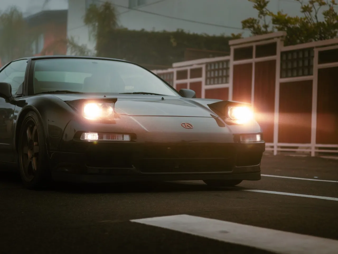 A black NSX with its pop-up headlights on