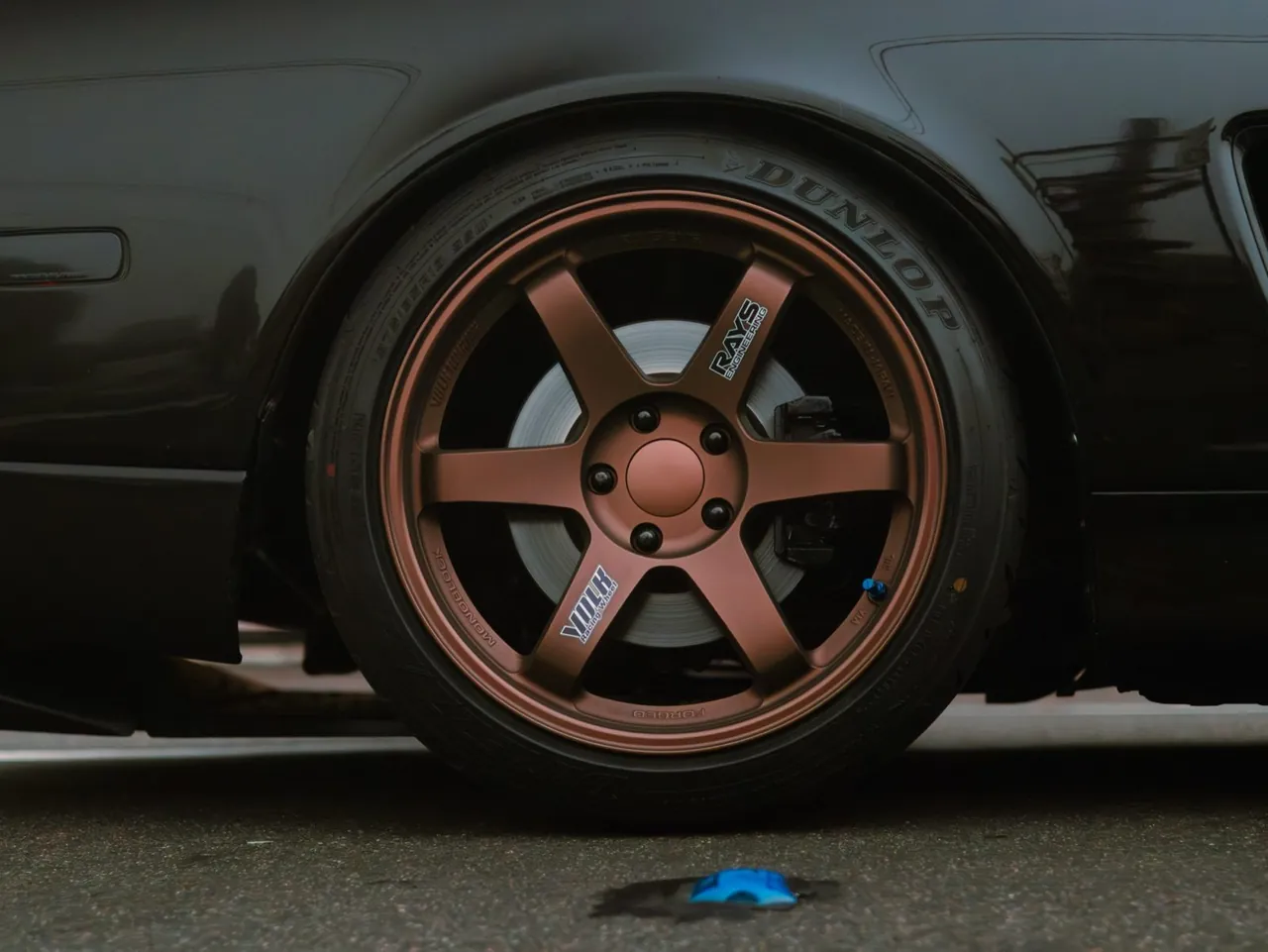 A bronze wheel on a dark car